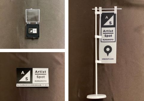 写真：アーティストスポット熊本のオリジナルロゴピンバッジ、オジリナルロゴステッカー、卓上のぼり旗